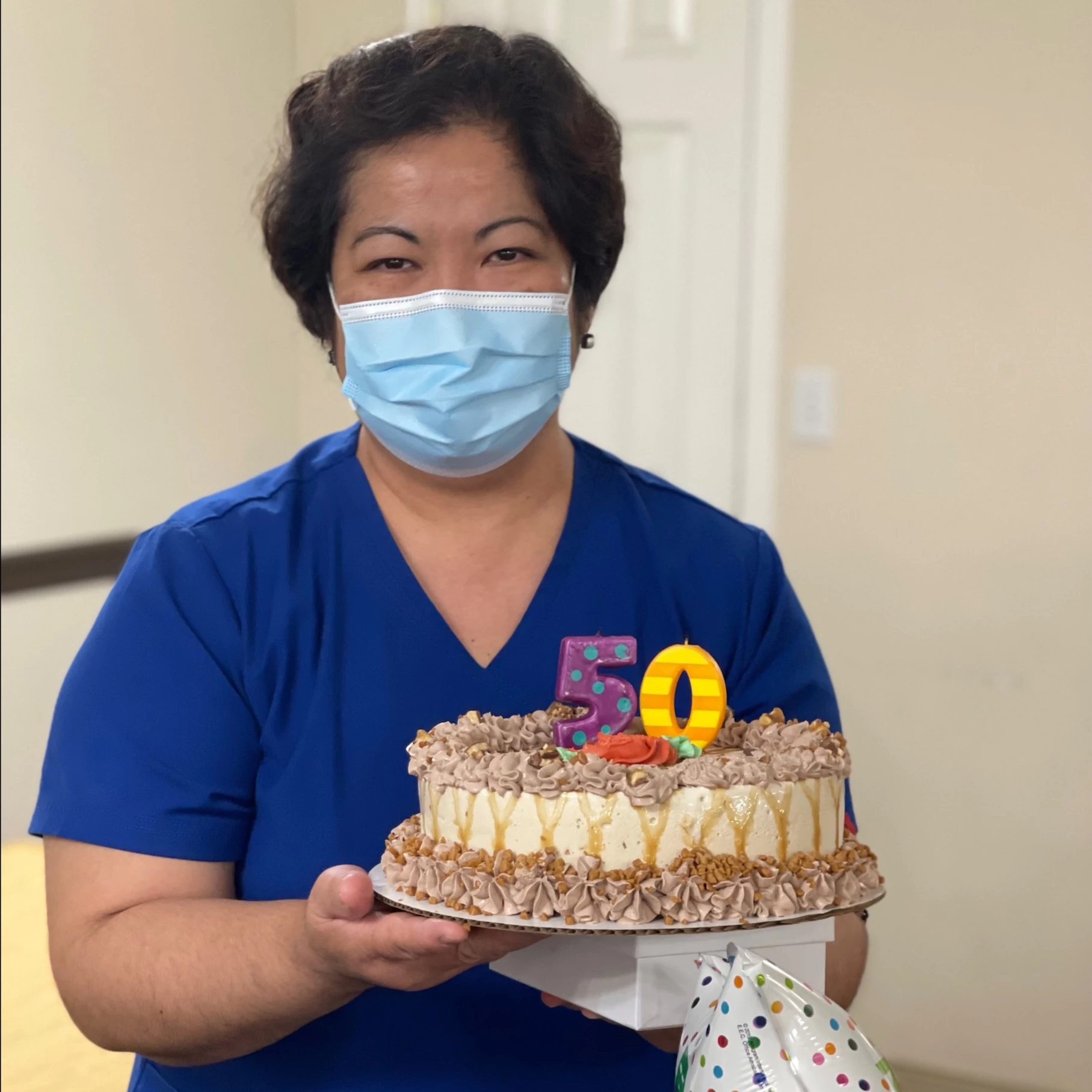 A lady holding cake on 50th birthday