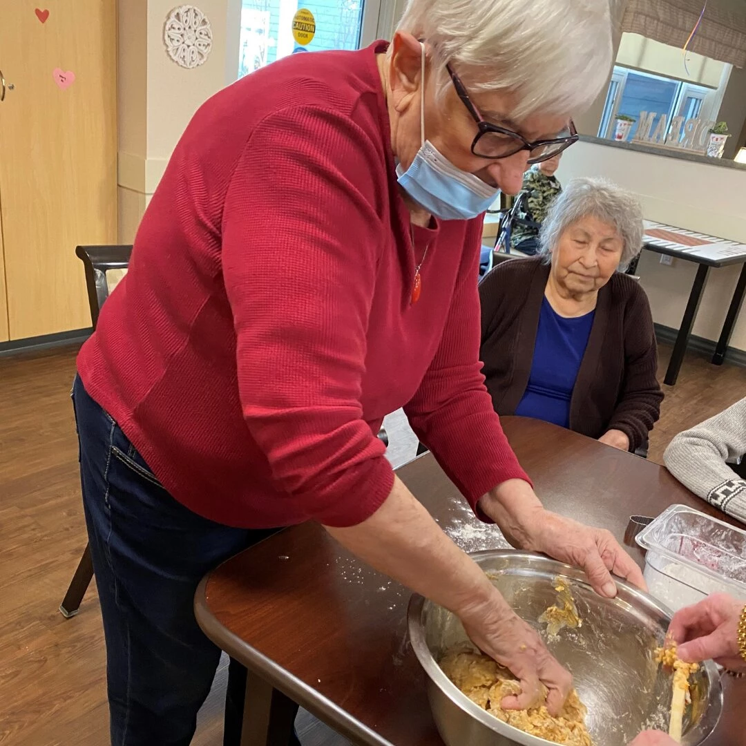 An elderly lady making something special