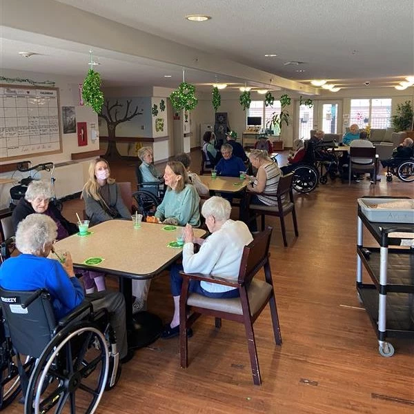 People seated around tables with St. Patrick's Day decorations spread around the room.