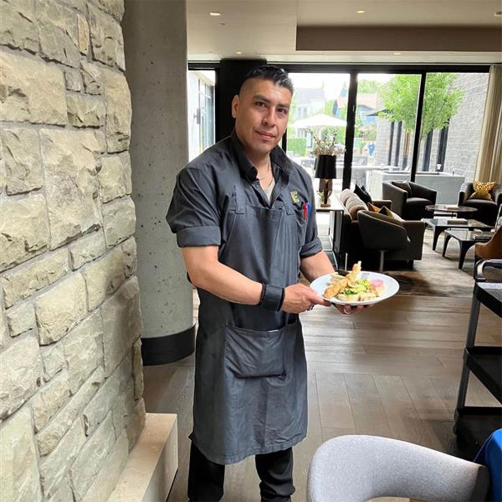 A chef holding a plate of lunch sandwiches