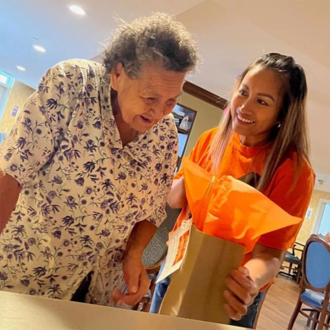 Senior receiving gift from a staff member