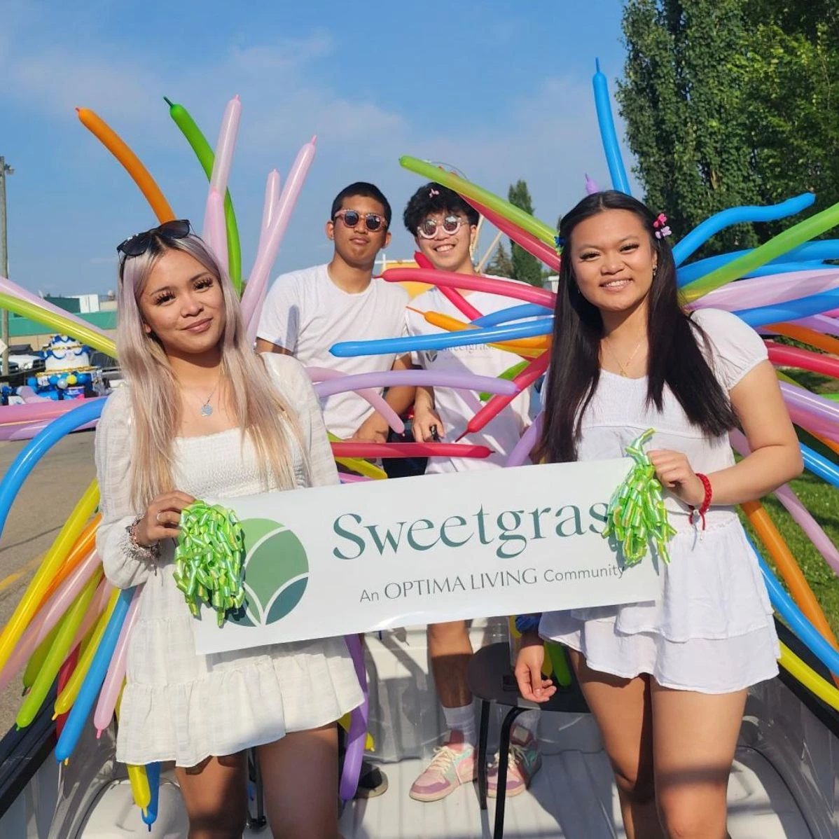 People holding up a Sweetgrass sign