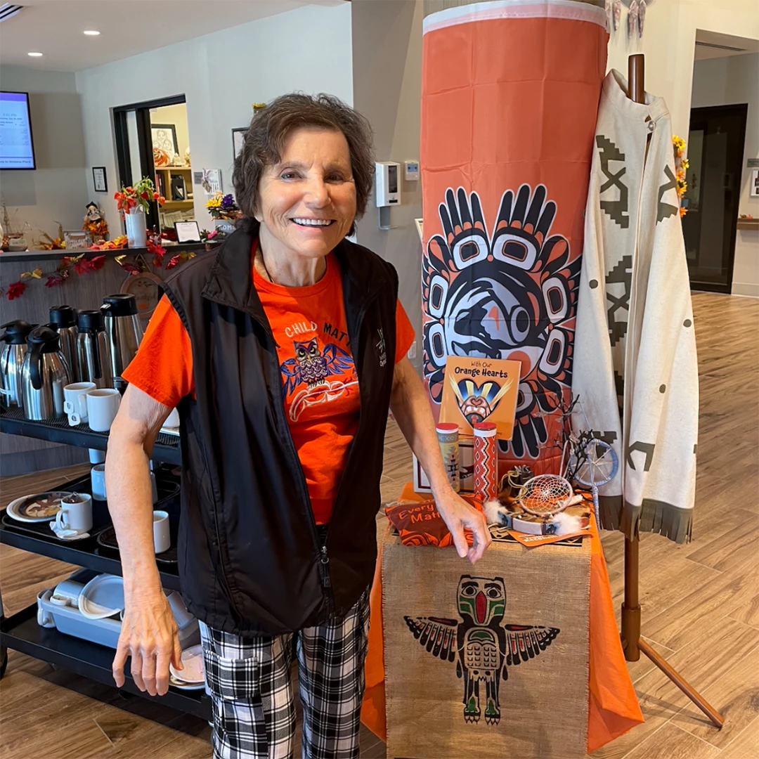 Senior standing with a display for Truth and Reconciliation