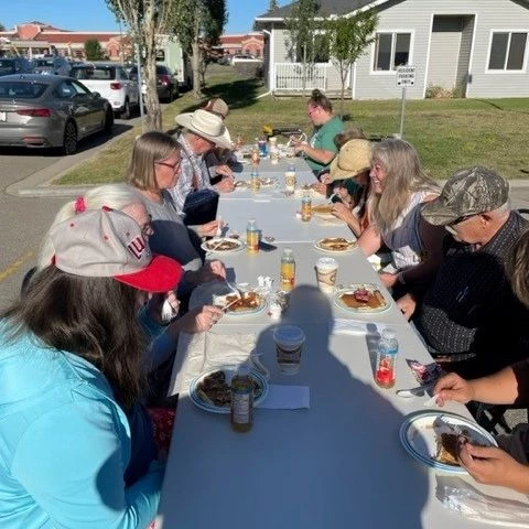 Seniors seated together outside enjoying a meal